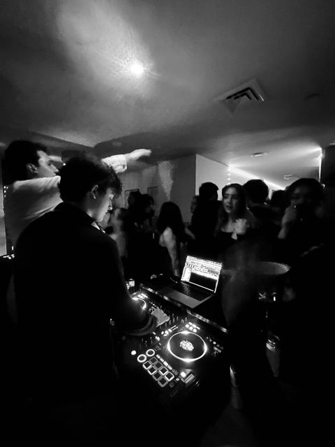 A house party, the crowd packed around the decks.